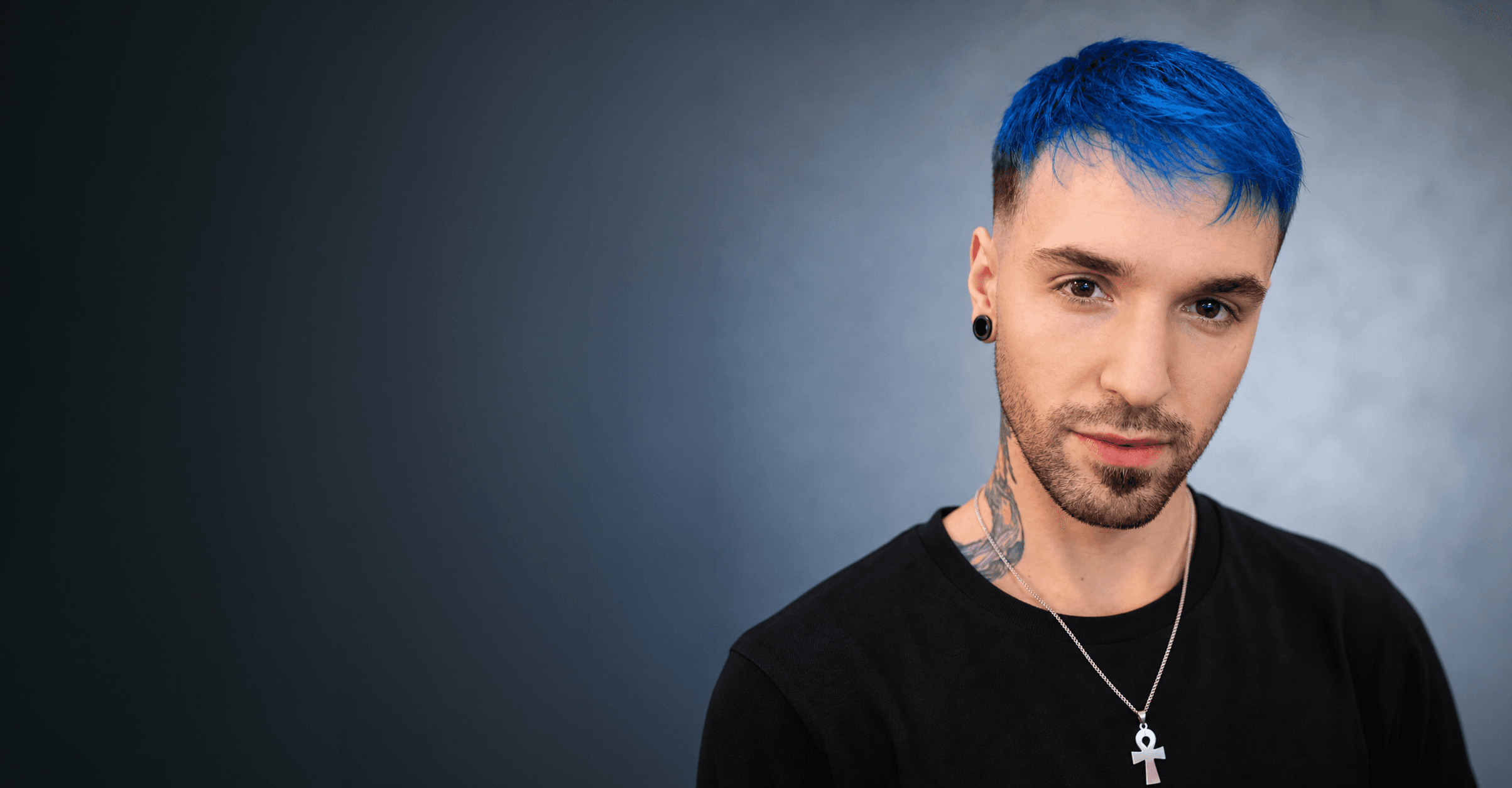 Javier Calzolari, con pelo azul, mirando a cámara