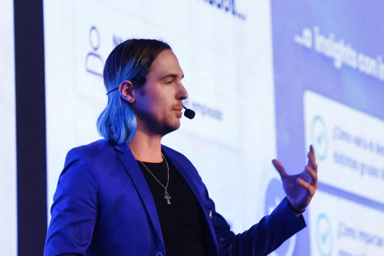 Javier Calzolari en el escenario, con saco azul y micrófono de diadema, durante una presentación